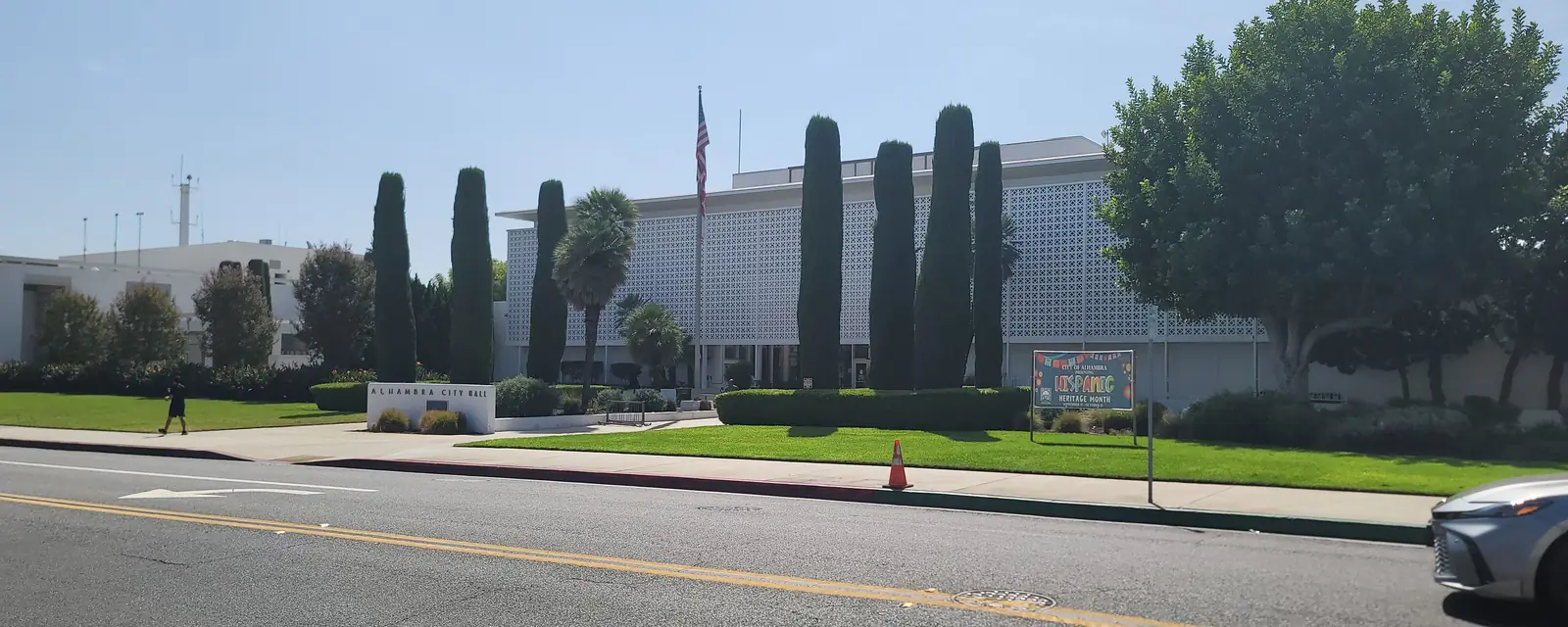 Alhambra’s civic center behind its lawn and tall cypress trees