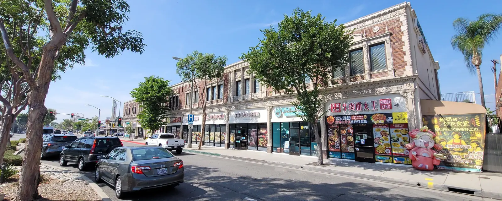 A historic brick block of shops with Chinese and English signs in Alhambra