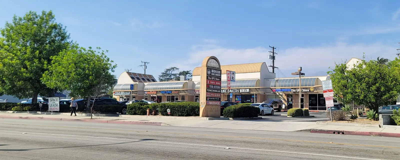 A small shopping plaza with a tall sign in Arcadia