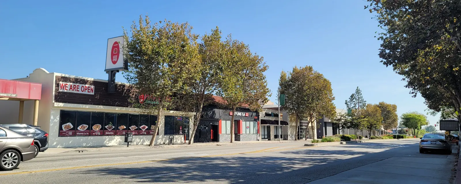 A row of restaurants and shops along a wide street in Arcadia