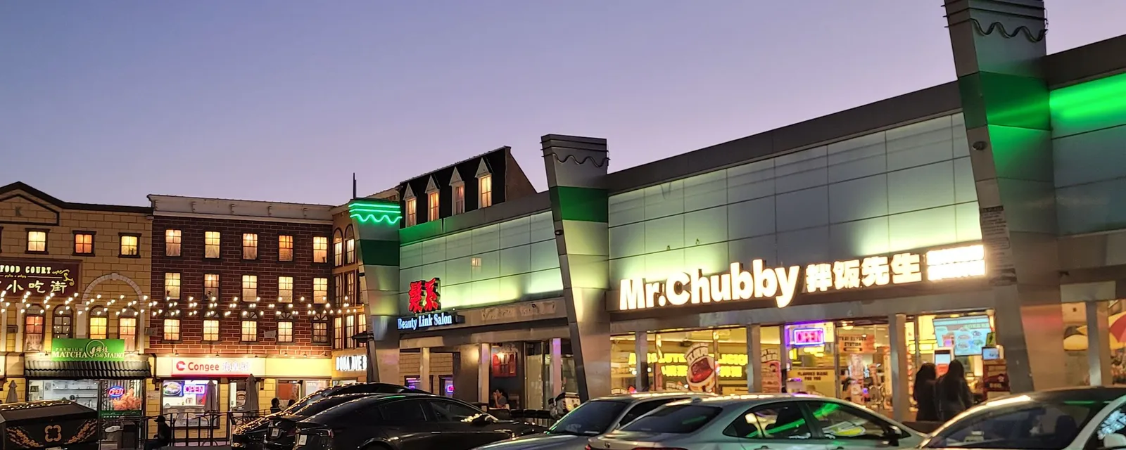 A fast-food storefront and a beauty salon in a Rowland Heights plaza at dusk