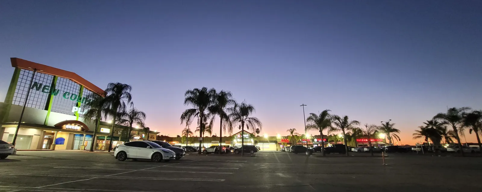 Sunset over a Rowland Heights parking lot lined with palm trees