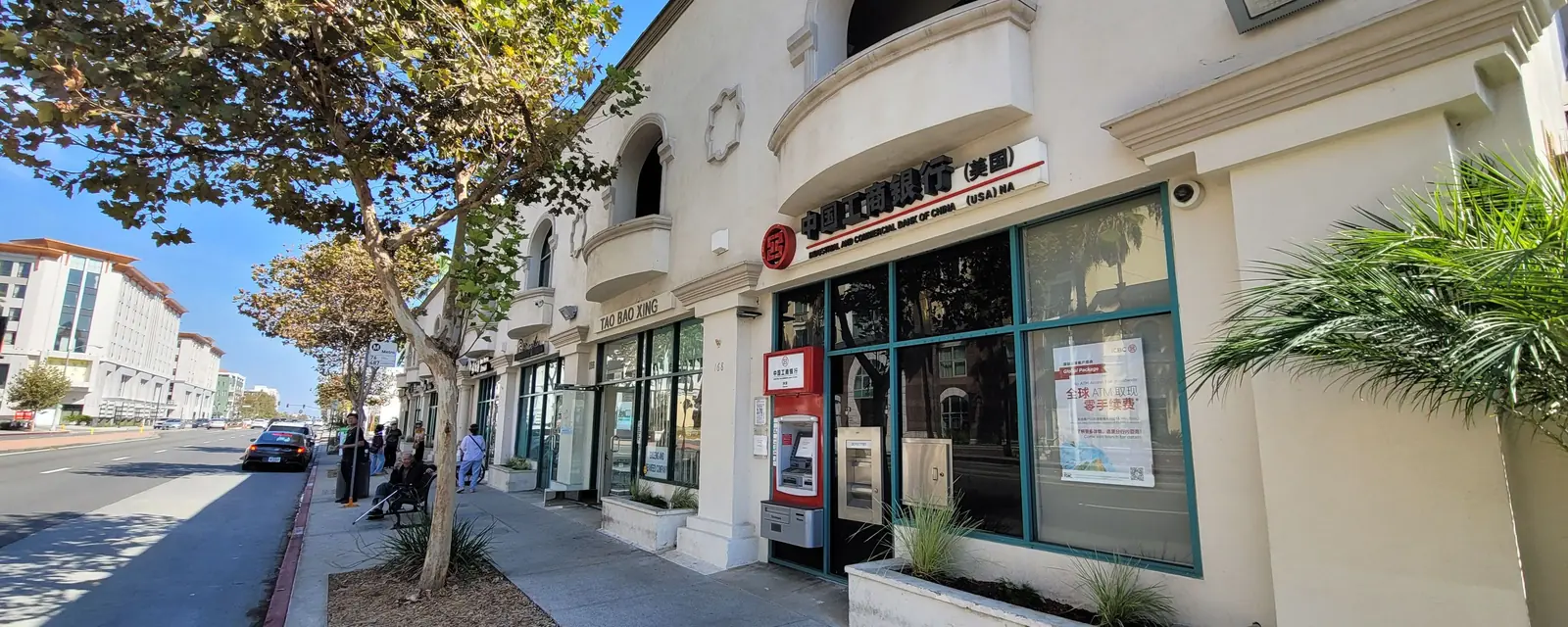 An arched storefront on a tree-lined sidewalk in San Gabriel